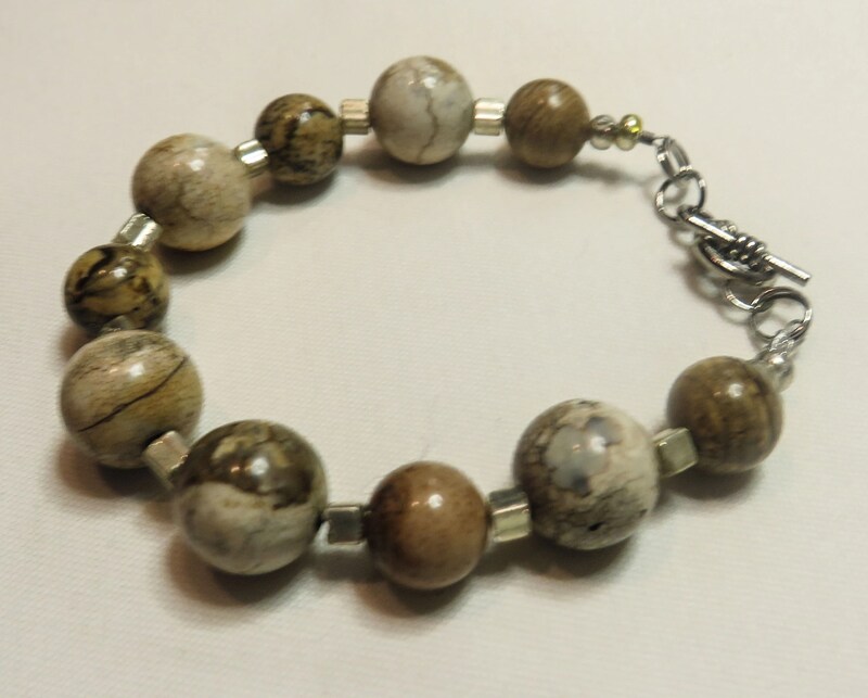 bracelet with various round earth-toned beads with silver accents with toggle closure